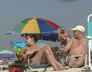 Big-boobed girl sunbathing in a bare beach